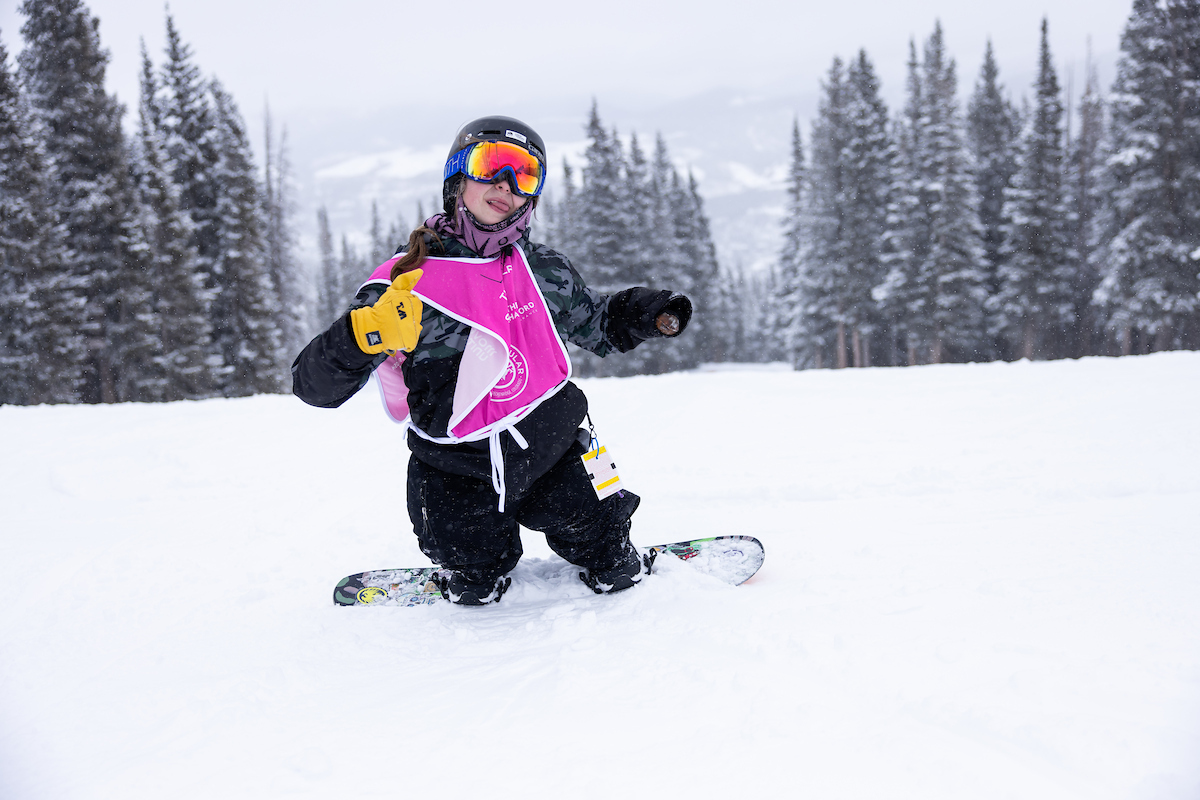 Adaptive Snowboarder on hill giving thumbs up