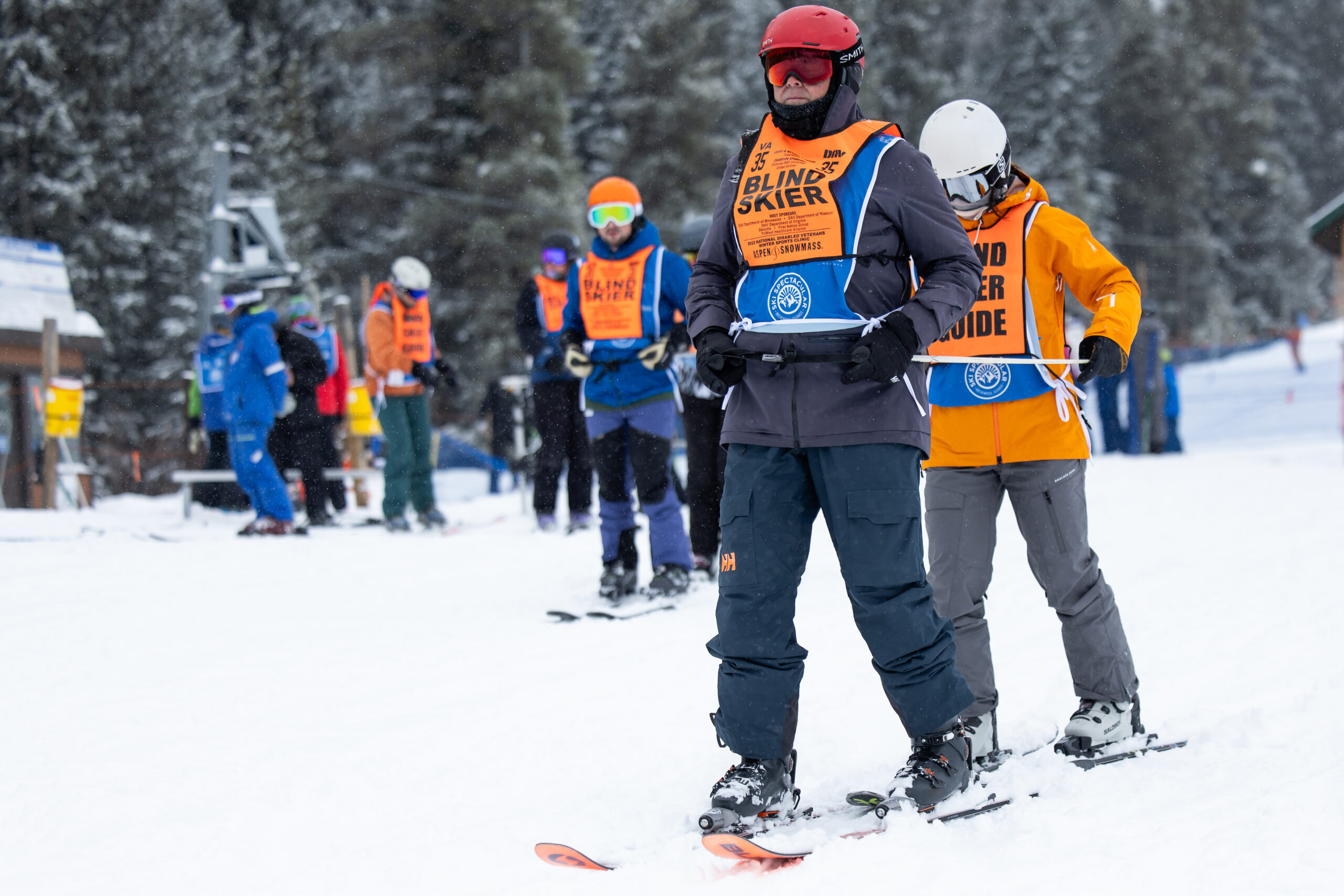 A group of blind skiers and their guides skiing down the hill
