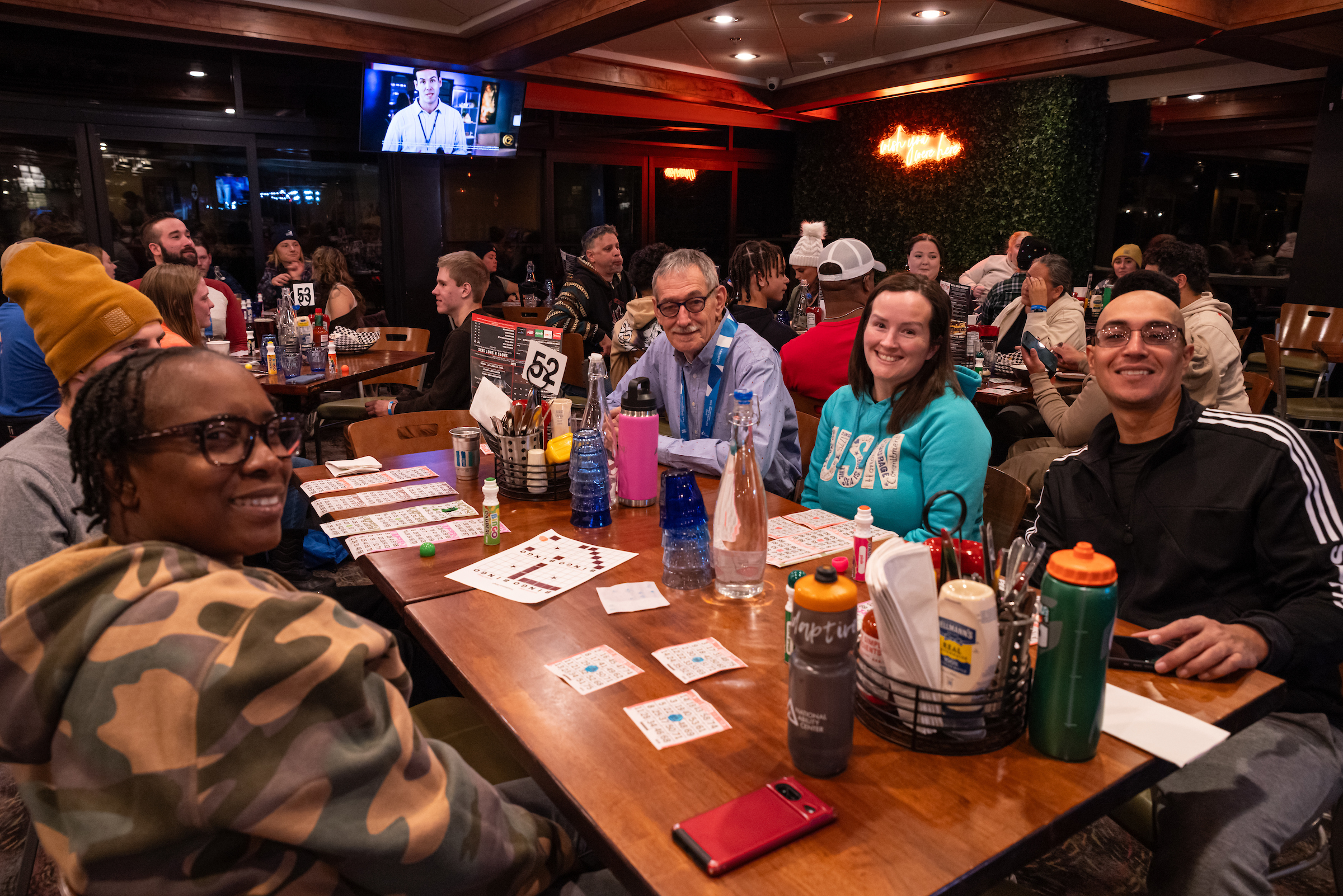 A group sitting at a restaurant table enjoying company and playing bingo