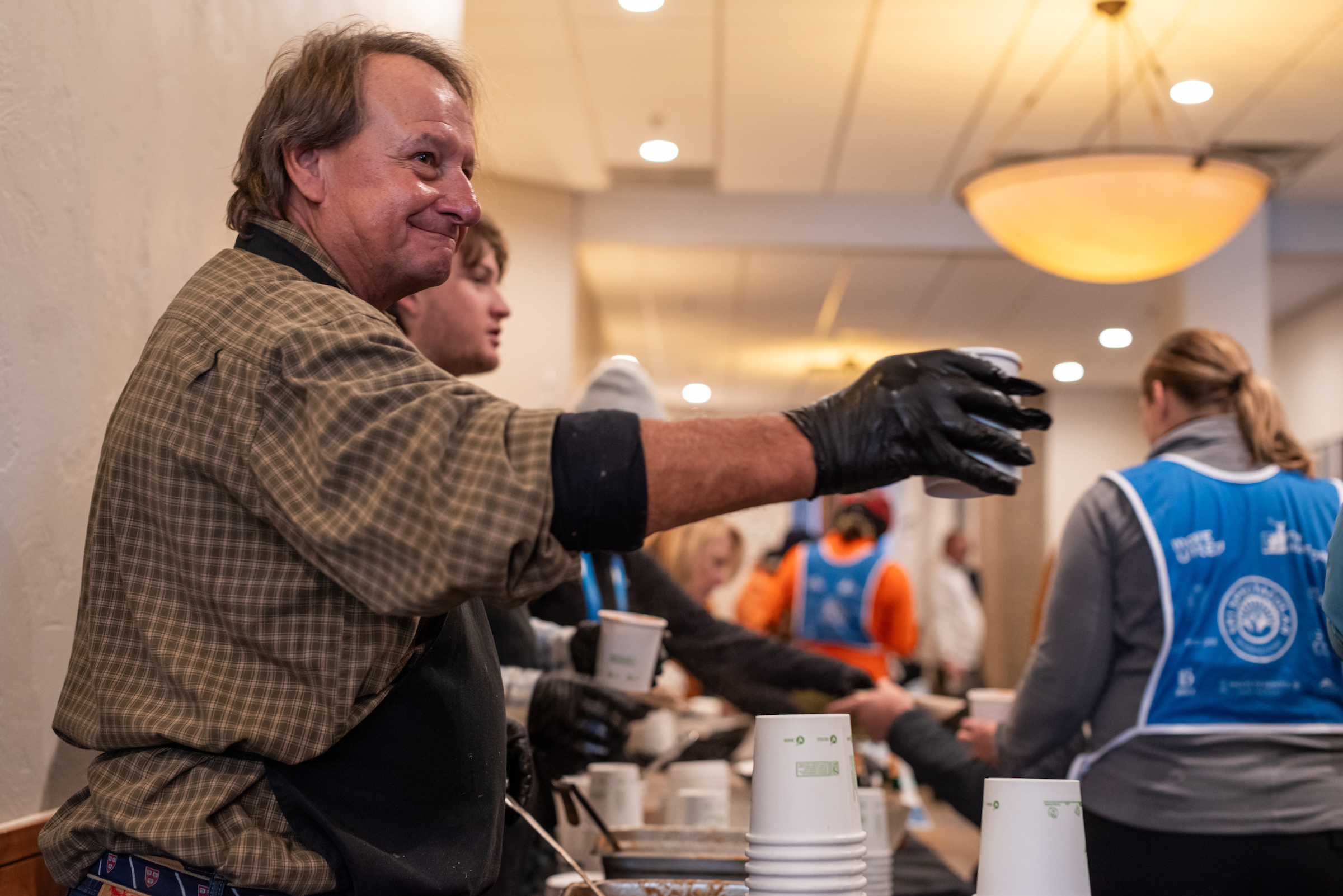 Volunteers serve soup to Ski Spec attendees indoors