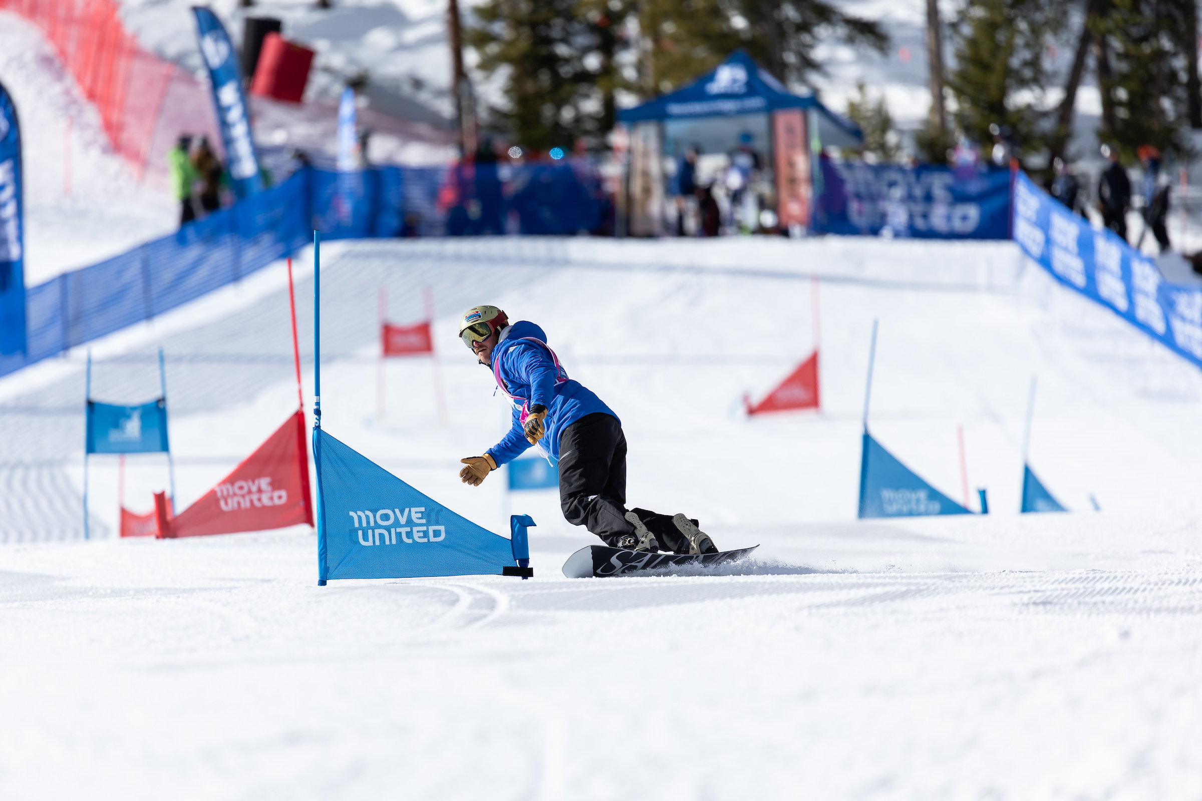 Adaptive Snowboarder racing through gates with various marketing assets in the background