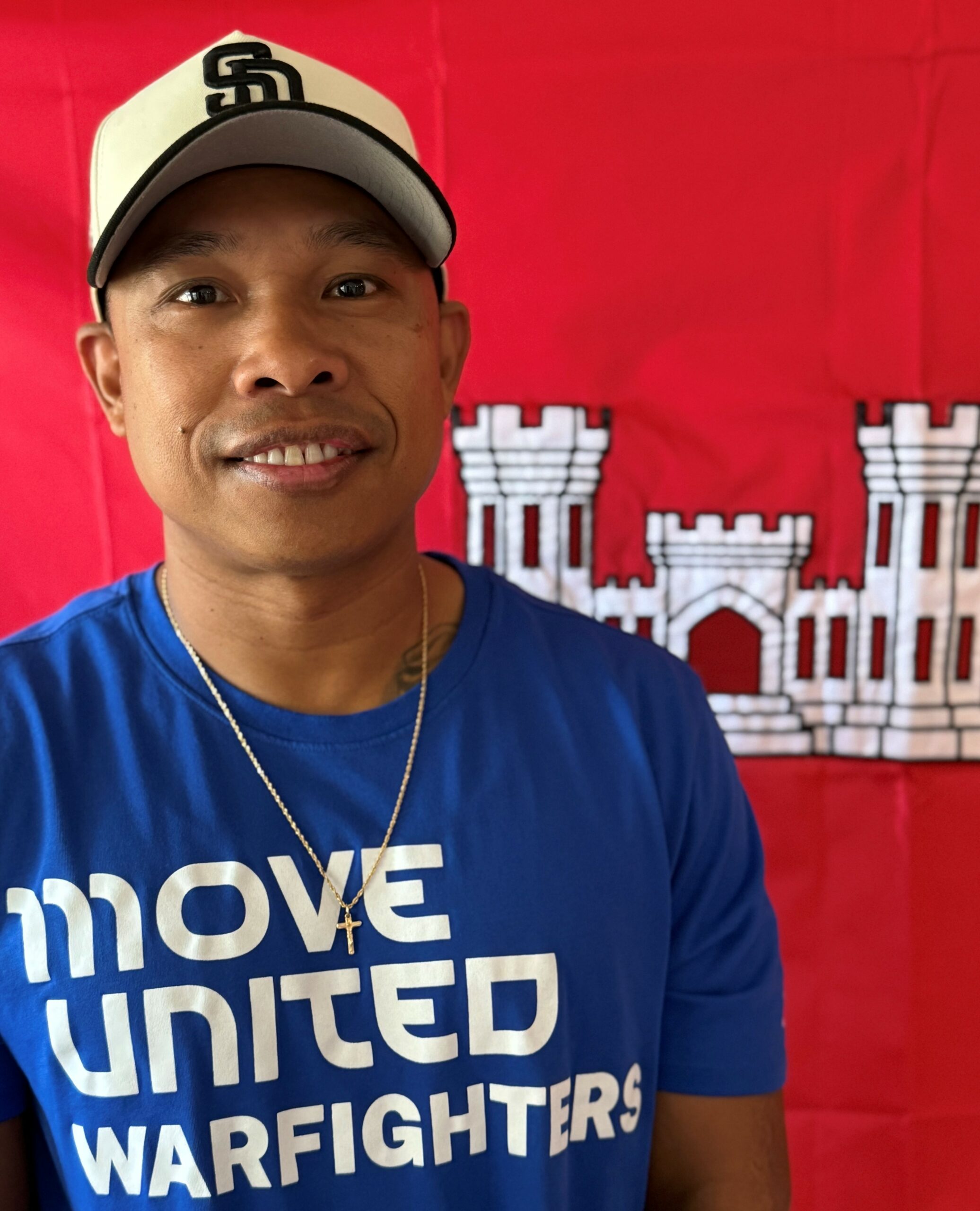 U.S. Army veteran Gene Calantoc smiling while wearing a Move United Warfighters T-shirt and a baseball cap