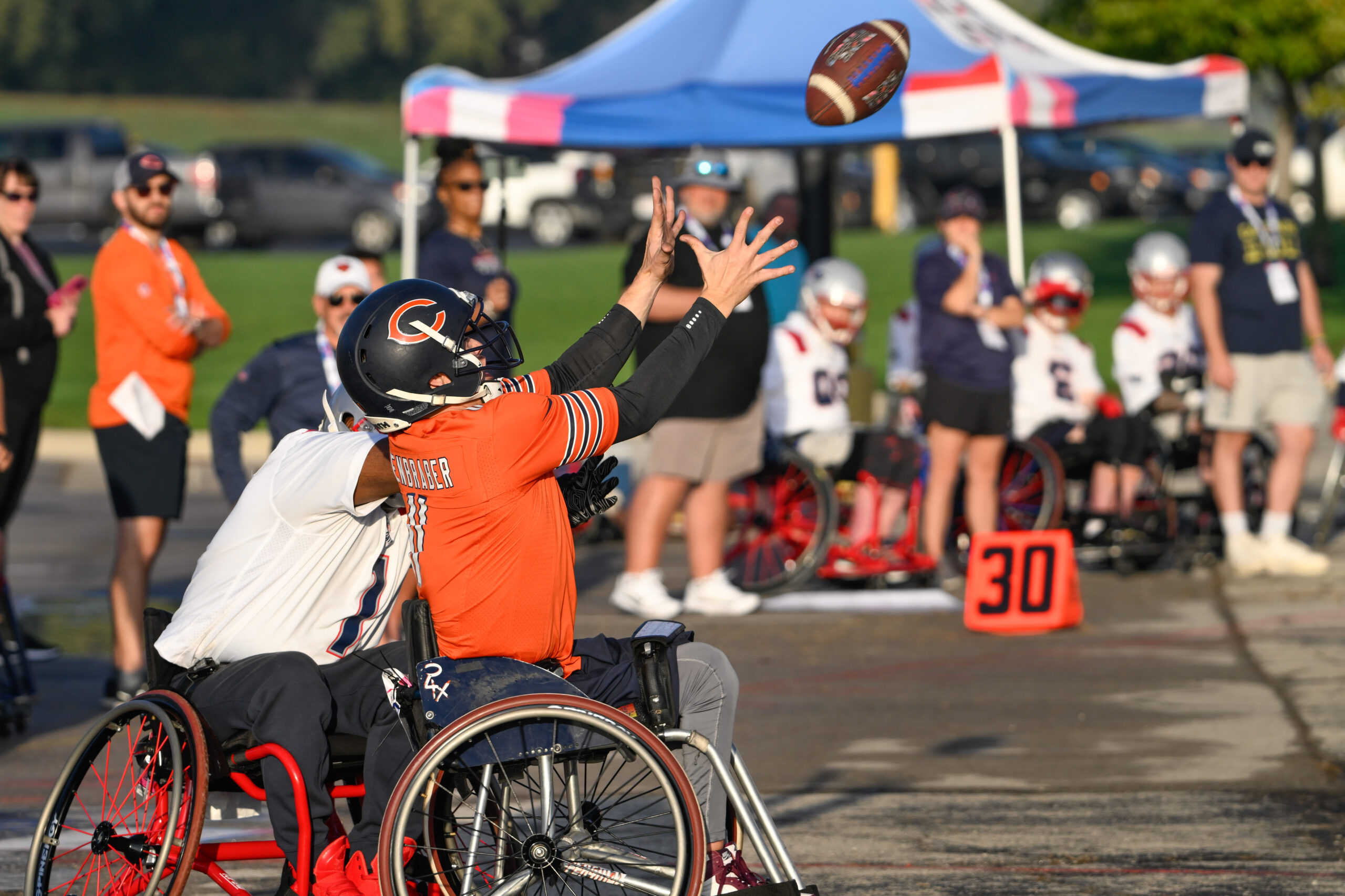 Image of Chicago Bears athlete catching a pass in wheelchair football game.