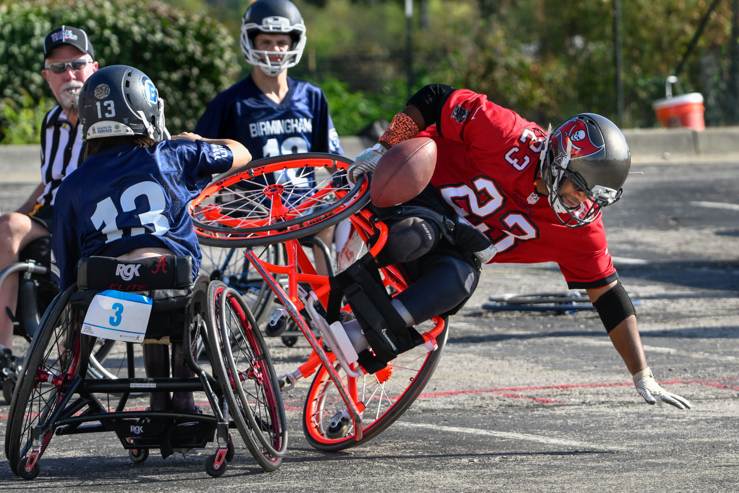 Image of wheelchair football player being tackled.