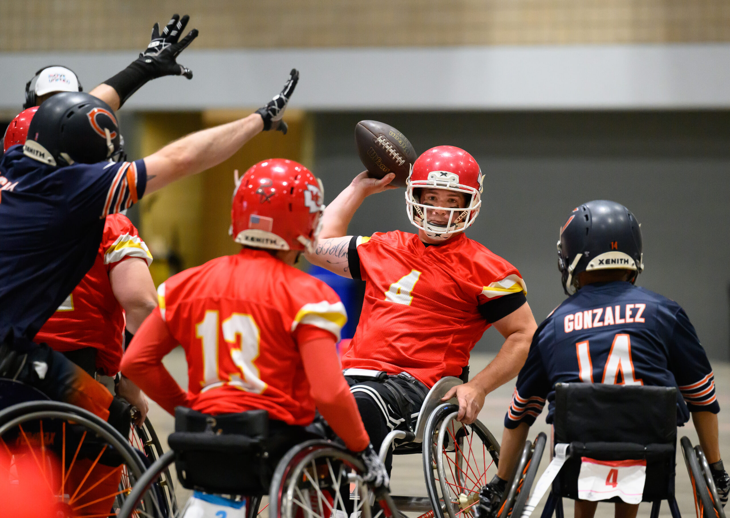 The quarterback for the Kansas City Chiefs Wheelchair Football Team prepares to throw the ball against the Chicago Bears team