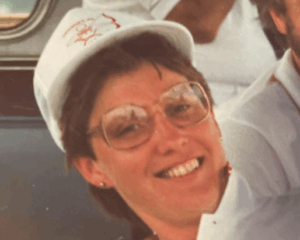Lyn Rourke wearing a cap, smiling