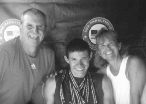 Gwena and Gerry Herman looking at camera with an athlete