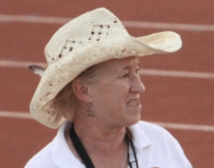 Pam Carey wearing a cowboy hat on a track