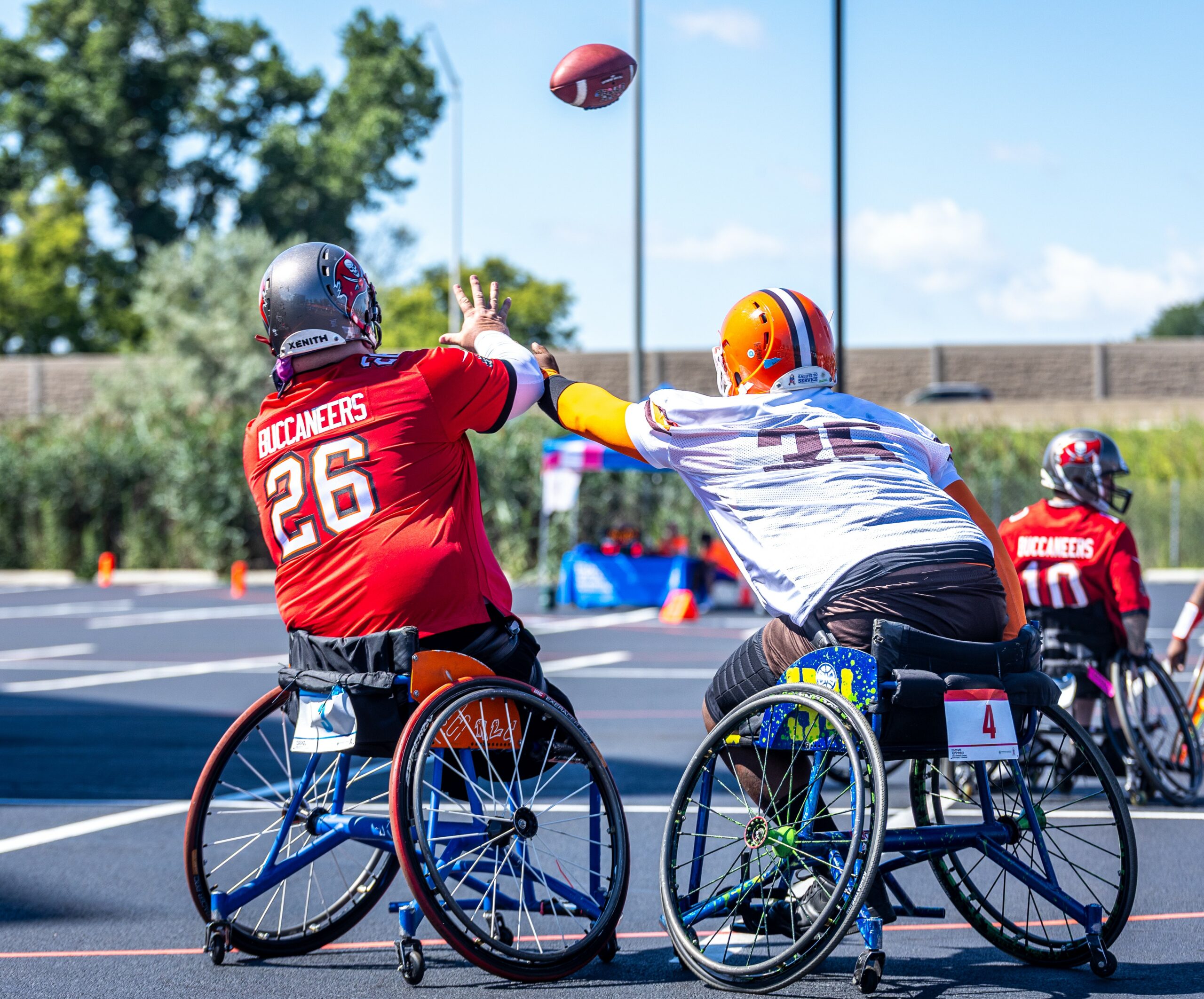 USAWFL Tampa athlete attempting to catch a pass while a Cleveland athlete attempts to intercept
