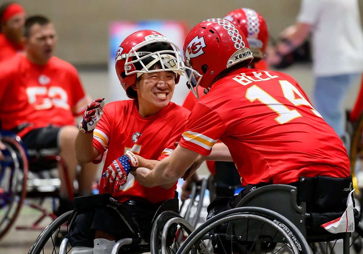 two kansas city wheelchair football team athletes cheering
