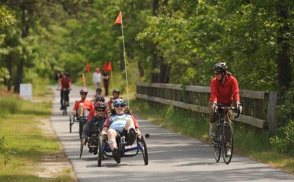 Group of people cycling with upright and recumbent bikes on a trail