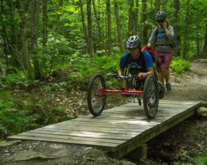 Individual using an adaptive mountain bike on a trail