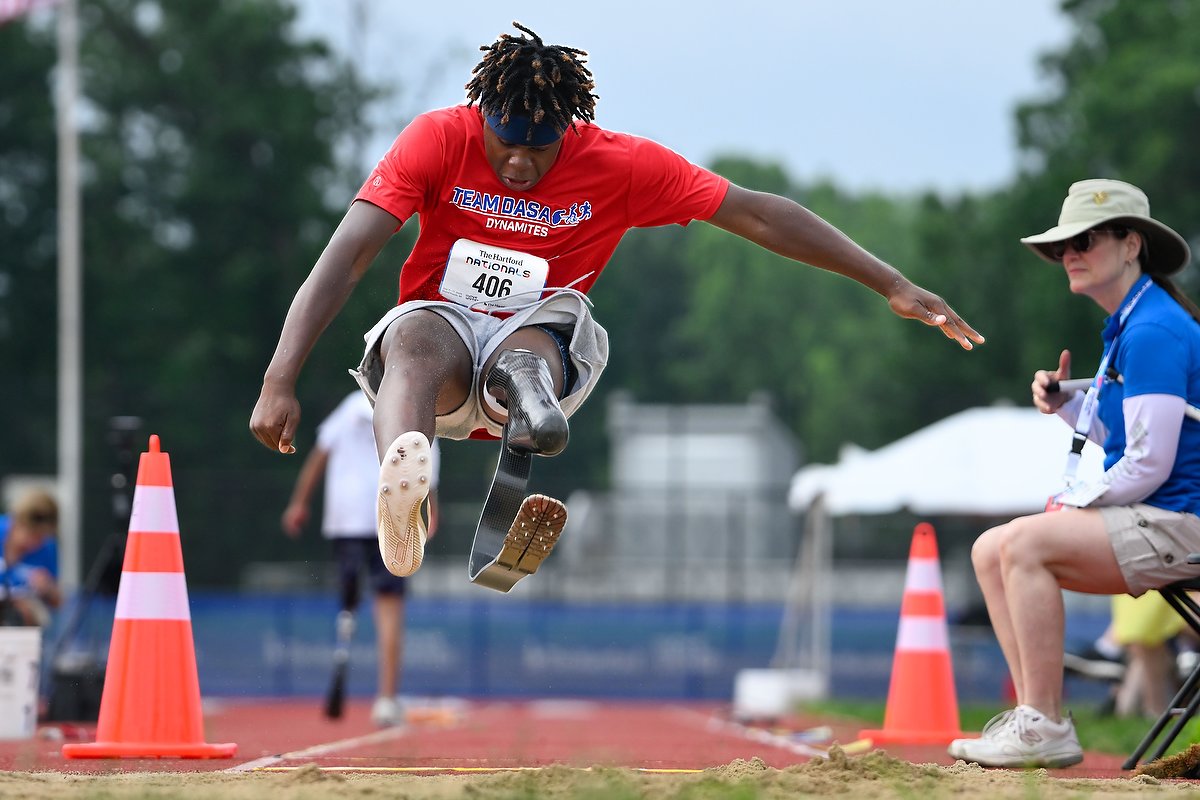 Young black athlete with leg amputation competing in long jump