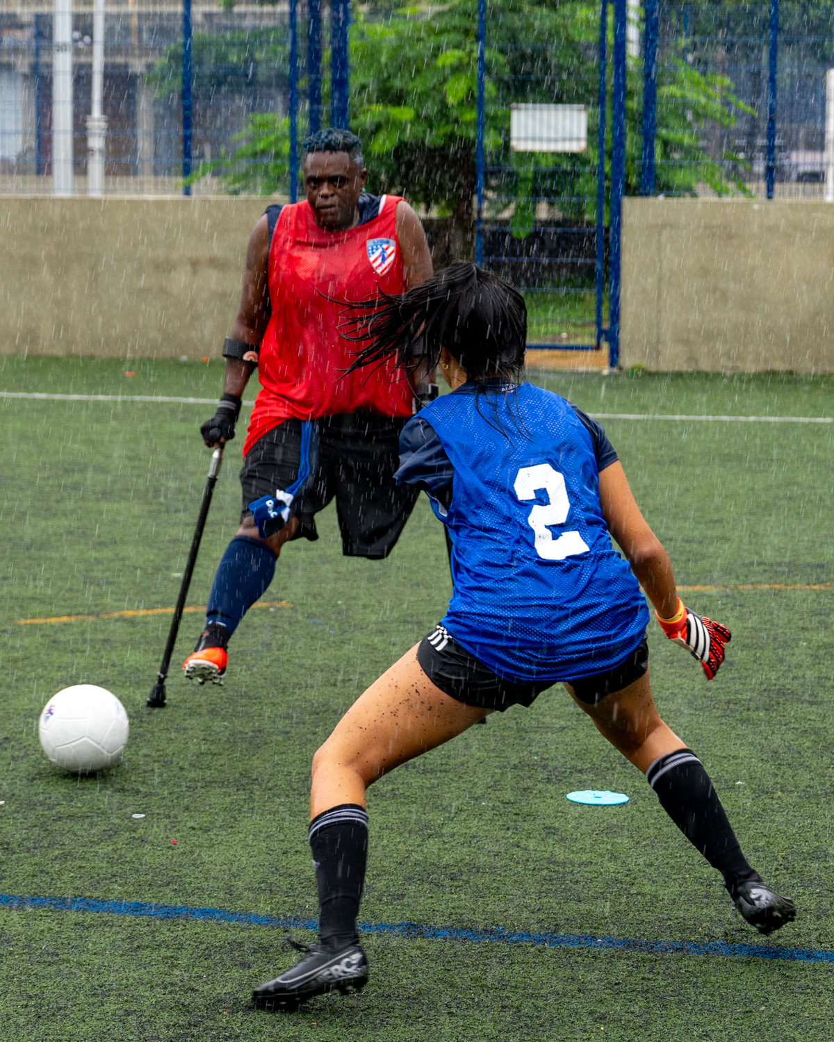 Move United athletes participating in amputee soccer in an outdoor field during heavy rain