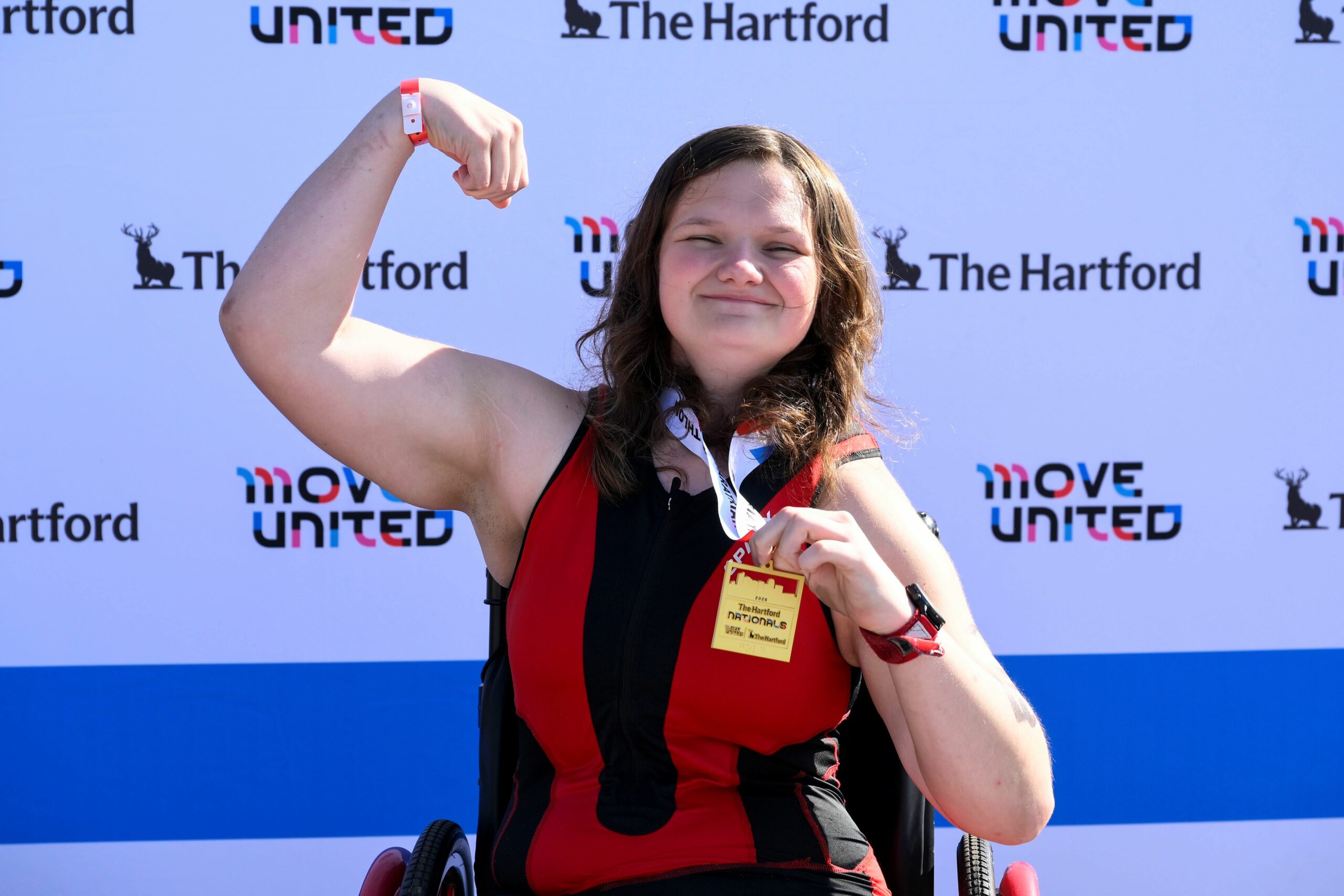 Athlete holding gold medal doing a victory pose